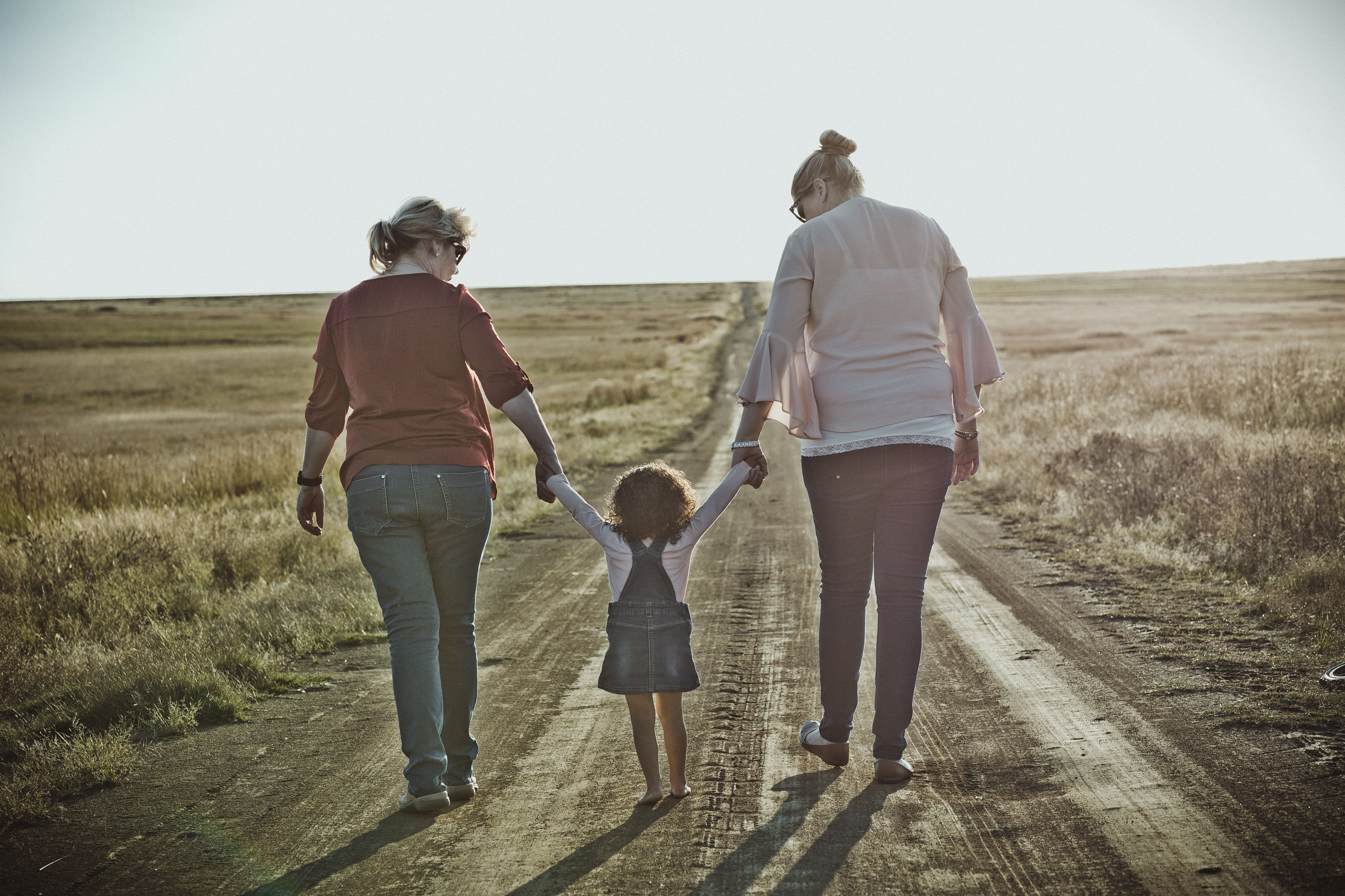estate planning attorneys - two adults holding a child, on a dirt road