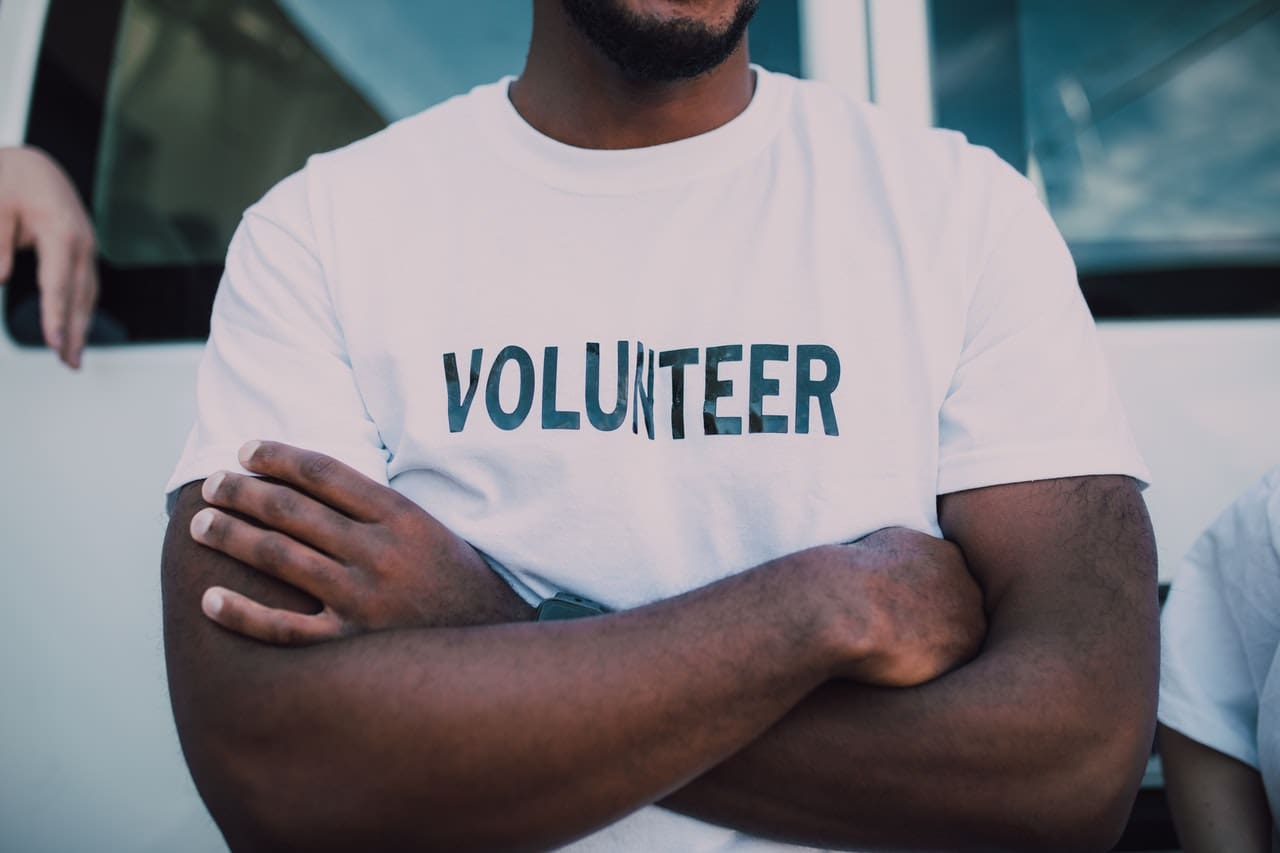 volunteer opportunities phoenix -- African American man wearing white t-shirt that says volunteer on it