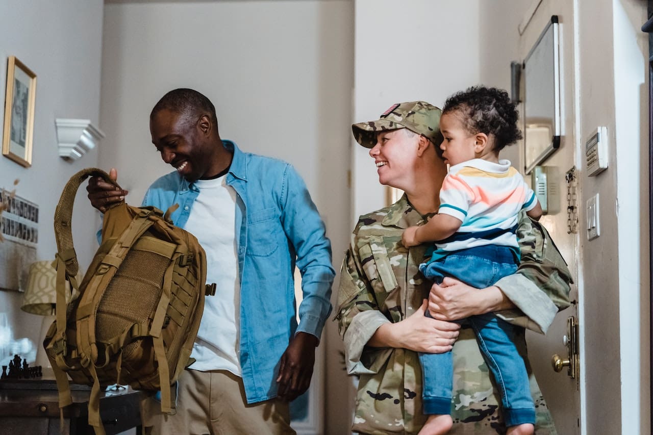 military couple holding child and laughing
