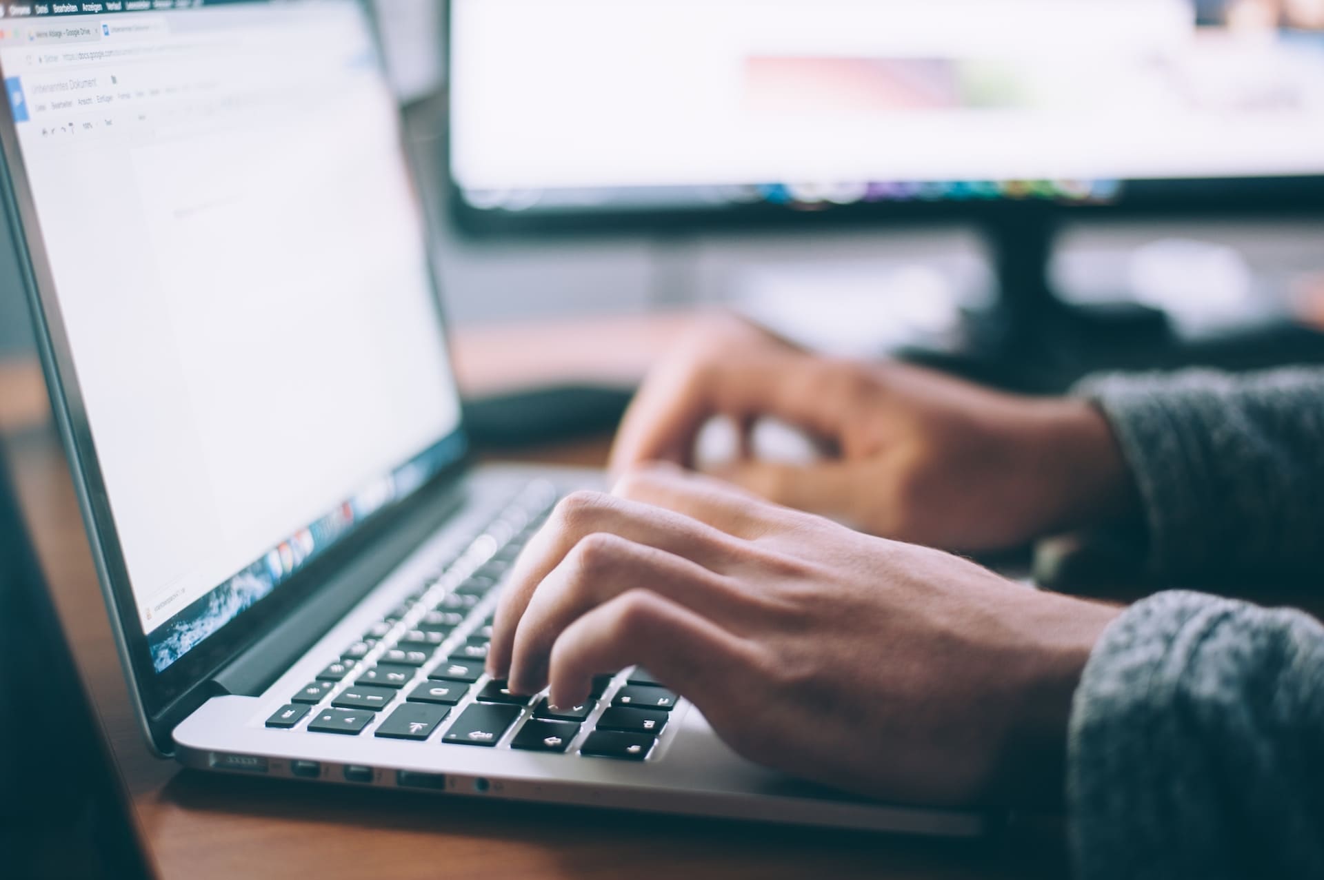 closeup of hands typing at a laptop