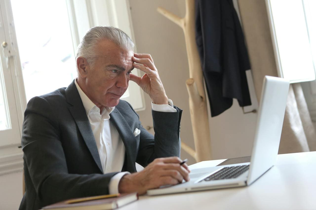 stressed man looking at computer