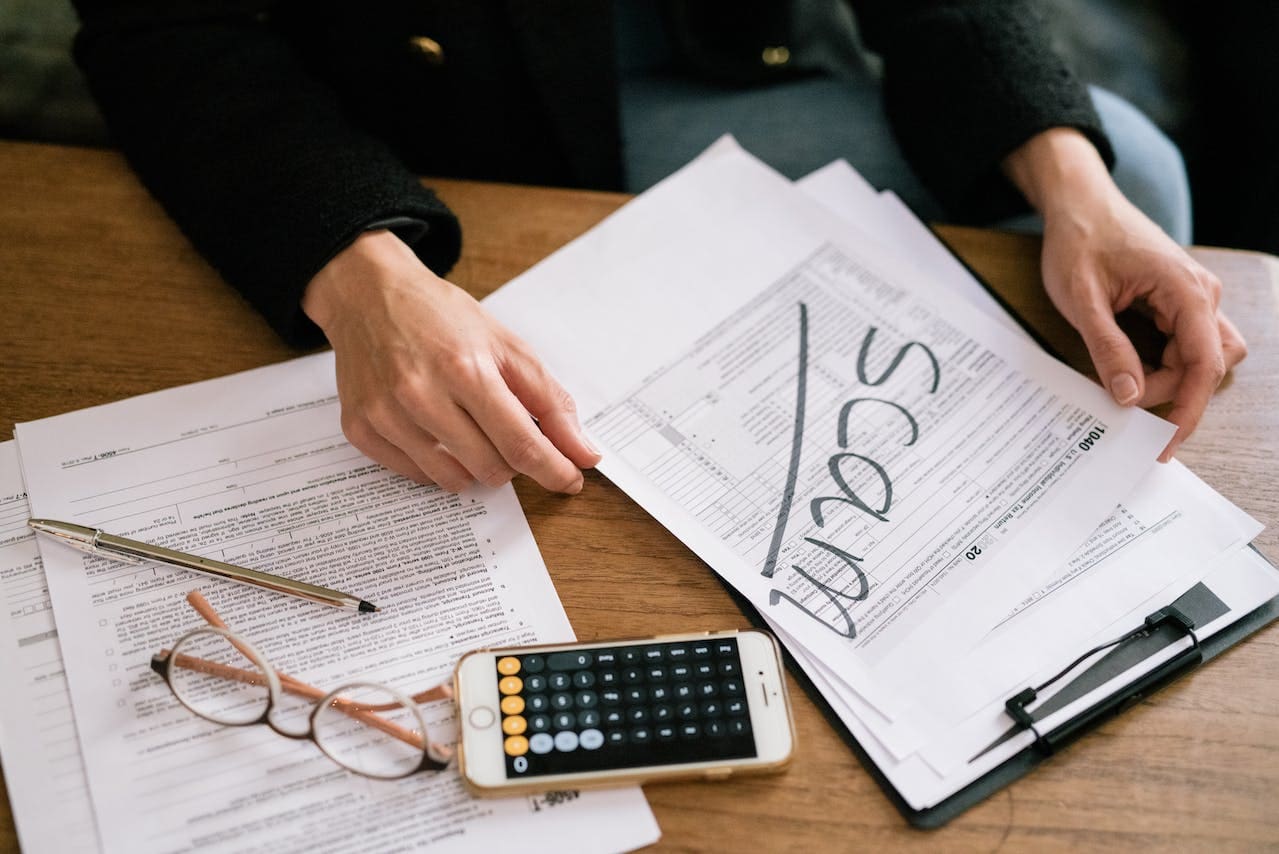 person holding documents with the word scam written on them